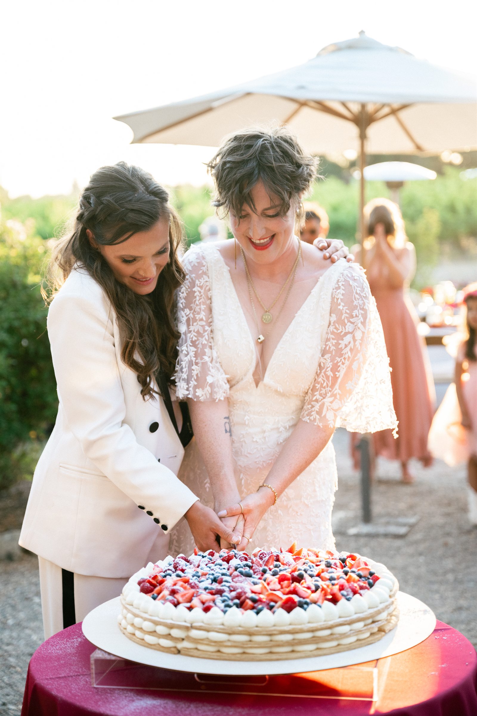 Couple cutting their berry pavlova wedding cake