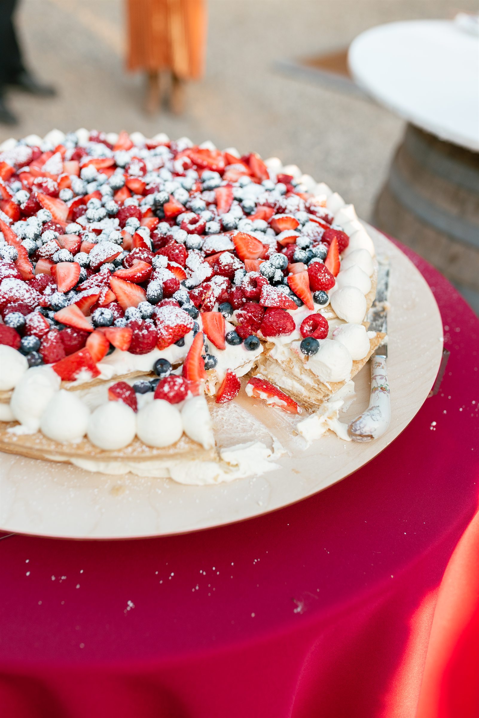 Berry pavlova wedding cake finished with fresh flowers